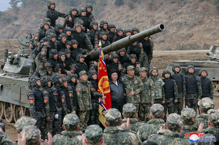 Nhà lãnh đạo Triều Tiên Kim Jong Un chụp hình cùng các binh sĩ tham gia cuộc trình diễn quân sự có các đơn vị xe tăng ở Triều Tiên, ngày 13-3 - Ảnh: KCNA