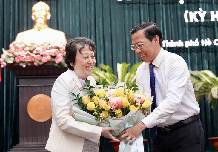 Chủ tịch UBND TP.HCM Phan Văn Mãi trao hoa chúc mừng bà Phạm Khánh Phong Lan - Ảnh: HỮU HẠNH 