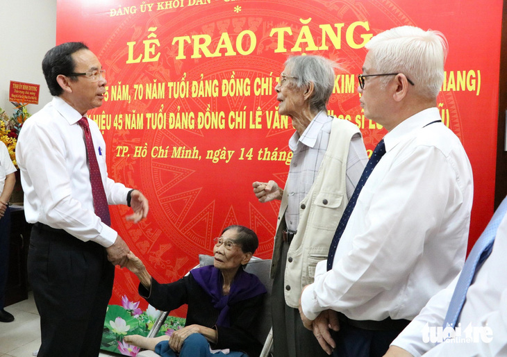 Bí thư Thành ủy TP.HCM (bìa trái) thăm hỏi gia đình nhạc sĩ Lư Nhất Vũ và nhà thơ Lê Giang - Ảnh: CẨM NƯƠNG