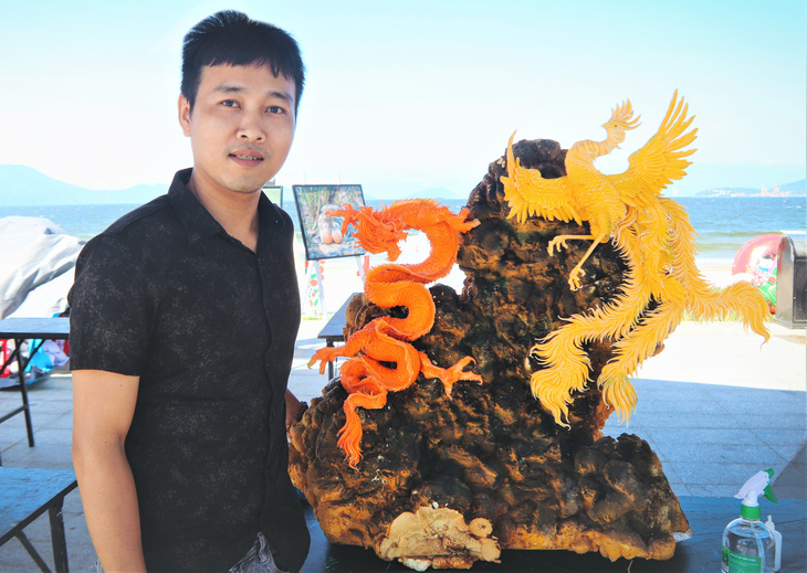 Nguyễn Anh Vũ cùng tác phẩm được dùng trang trí tại các lễ hội, cuộc thi - Ảnh: THANH NGUYÊN