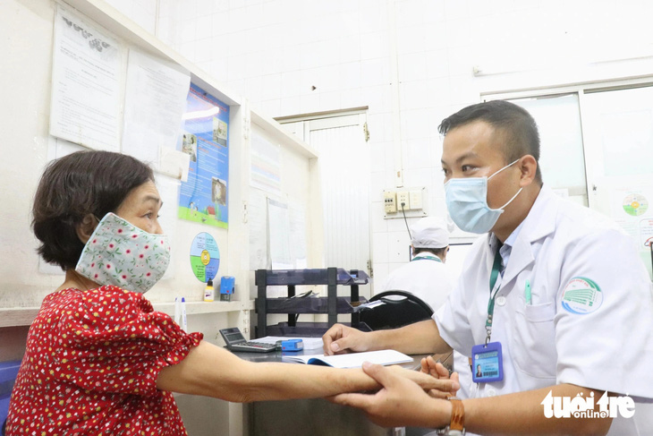 Bác sĩ CKII Danh Thơm - phó trưởng khoa khám bệnh Bệnh viện Bệnh nhiệt đới (TP.HCM) - khai thác thông tin, tư vấn người dân trước khi tiêm vắc xin dại - Ảnh: XUÂN MAI 