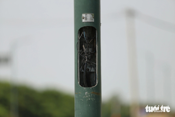 Cột đèn giao thông tại giao lộ Bùi Thiện Ngộ và Nguyễn Cơ Thạch cũng bị mất nắp đậy, dây điện thòng ra ngoài - Ảnh: MINH HÒA