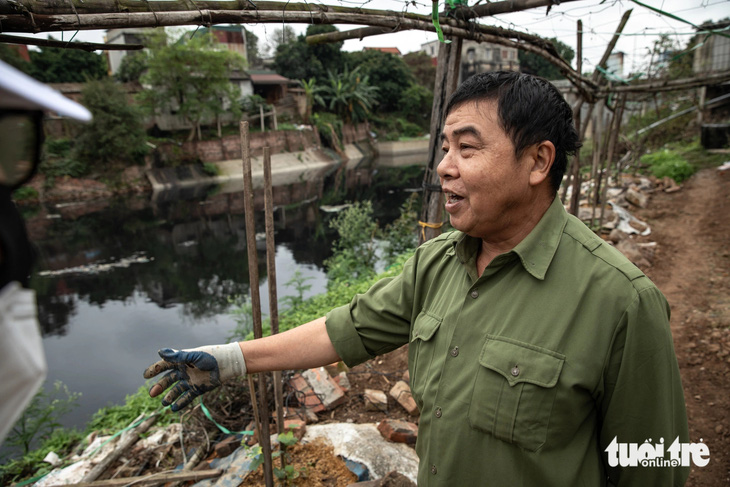 Ông Ninh (63 tuổi, ngụ phường Vạn An, TP Bắc Ninh) cho biết dù trồng rau cạnh cống tiêu Đặng Xá nhưng không dám lấy nước tưới - Ảnh: D.KHANG