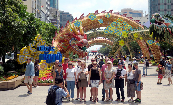 Du khách chụp ảnh lưu niệm với mô hình rồng lượn đường Nguyễn Huệ, quận 1, TP.HCM - Ảnh: T.T.D.