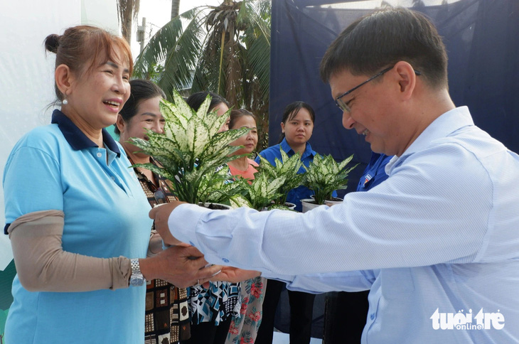 Trưởng Ban Dân vận Thành ủy TP.HCM Nguyễn Mạnh Cường (bên phải) trao cây xanh cho các hộ dân sống gần kênh Rạch Mướp - Ảnh: K.ANH