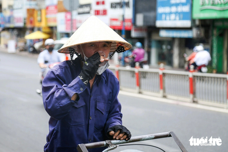 Người đàn ông che dù, chợp mắt nghỉ trưa trên đường Thành Thái (quận 10)
