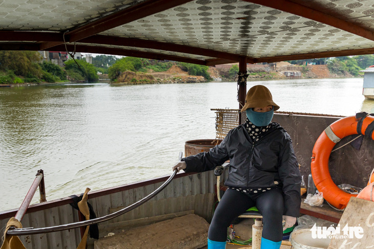 Bà Hiền, người lái đò đưa khách qua lại giữa TP Bắc Ninh với thị xã Việt Yên, cho biết nước thải đổ ra sông Cầu có ngày thối nhức mũi - Ảnh: D.KHANG