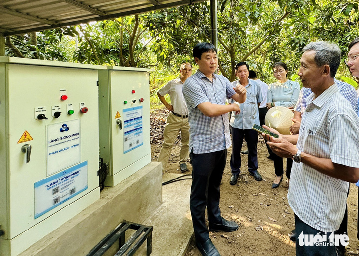 Ông Lê Quốc Phong - bí thư Tỉnh ủy Đồng Tháp (bìa trái) - khảo sát hệ thống tưới nước thông minh vận hành bằng cảm biến trên ứng dụng điện thoại tại Tâm Quê hội quán tưới nước cho 0,5ha xoài - Ảnh: ĐẶNG TUYẾT