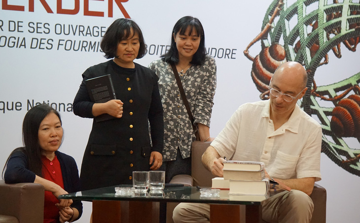 Nhà văn Bernard Werber ký tặng sách cho độc giả tại  Hà Nội  - Ảnh: T.ĐIỂU