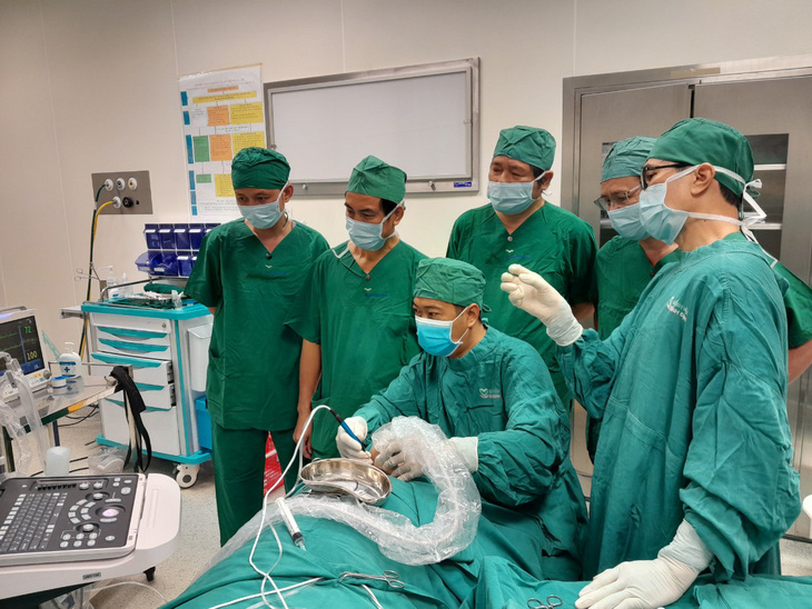 TS.BS Trần Minh Bảo Luân (người ngồi) cùng các bác sĩ Bệnh viện Bình Định thực hiện thủ thuật điều trị nhân giáp lành tính bằng sóng cao tần (RFA) - Ảnh: MINH DUYÊN