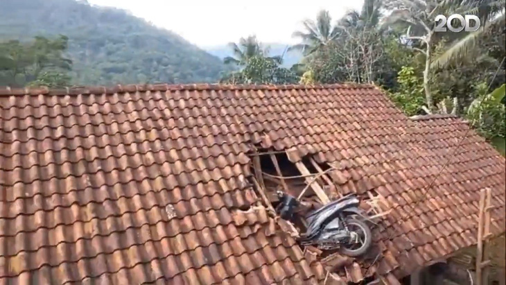 Chiếc xe máy trên mái nhà sau khi hai học sinh được đưa xuống - Ảnh: Detik News