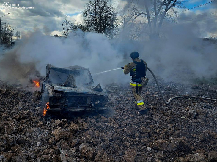 Lính cứu hỏa Ukraine làm việc sau cuộc tấn công bằng tên lửa của Nga ở Mykolaiv, ngày 17-3 - Ảnh: REUTERS