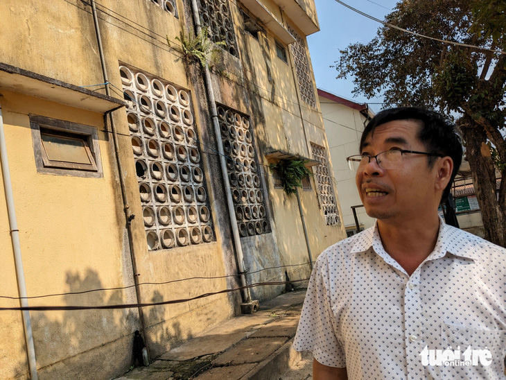 Ông Võ Thành Nguyên - hiệu trưởng Trường Phổ thông dân tộc nội trú tỉnh Gia Lai, đi xem phần tường đã mọc rêu của ký túc xá - Ảnh: TẤN LỰC 