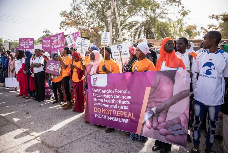 Nhiều người giương biểu ngữ kêu gọi các nhà lập pháp Gambia không bãi bỏ lệnh cấm hủ tục "cắt âm vật nữ" bên ngoài quốc hội ngày 18-3 - Ảnh: REUTERS