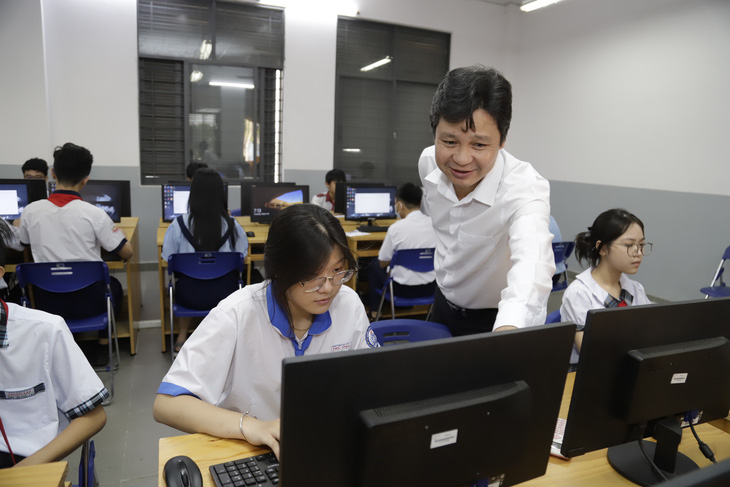 Thí sinh và giám thị đang kiểm tra máy tính trước khi làm bài thi môn tin học, kỳ thi chọn học sinh giỏi lớp 9 cấp thành phố năm 2024 tại điểm thi Trường THPT chuyên Lê Hồng Phong -  Ảnh: NHƯ HÙNG
