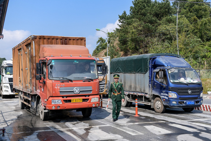 Lực lượng bộ đội biên phòng hướng dẫn lái xe hàng từ Trung Quốc làm thủ tục nhập khẩu - Ảnh: NAM TRẦN