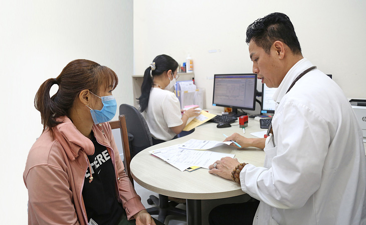 Bác sĩ chuyên khoa 2 Nguyễn Thanh Huy (khoa khám bệnh Viện Tim TP.HCM) đọc kết quả cho bệnh nhân chiều 18-3 - Ảnh: PHƯƠNG QUYÊN