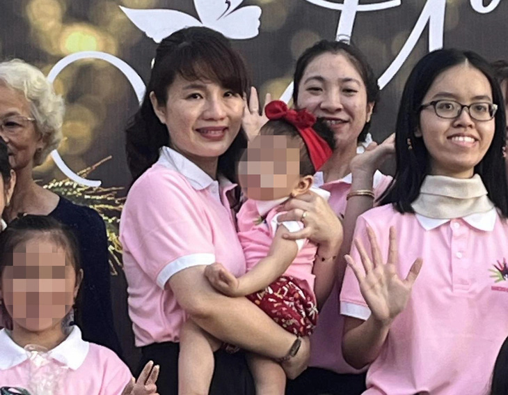 Con gái chị N. (đeo nơ đỏ trên đầu) được BS Nguyễn Thị Thanh Hương - phó giám đốc Bệnh viện Nhi đồng 1 - bế trong ngày bệnh hiếm vừa được tổ chức tại Bệnh viện Nhi đồng 1 - Ảnh: THÙY DƯƠNG