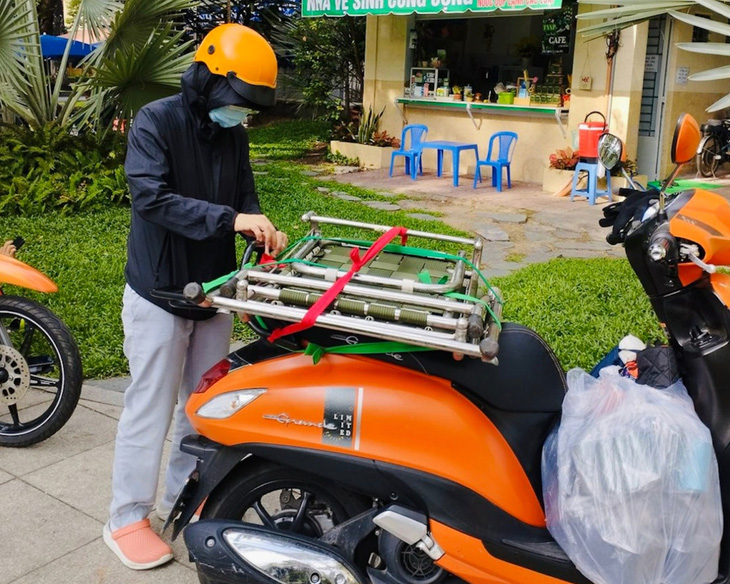 Một cô gái trên nhóm Freecycle Saigon chở chiếc ghế dựa đến tặng bà Cẩm Hồng - Ảnh: Y. TRINH
