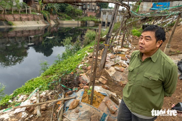 Ông Ninh (63 tuổi, ở phường Vạn An, TP Bắc Ninh) cho biết dù trồng rau cạnh cống tiêu Đặng Xá nhưng không dám lấy nước tưới - Ảnh: D.KHANG