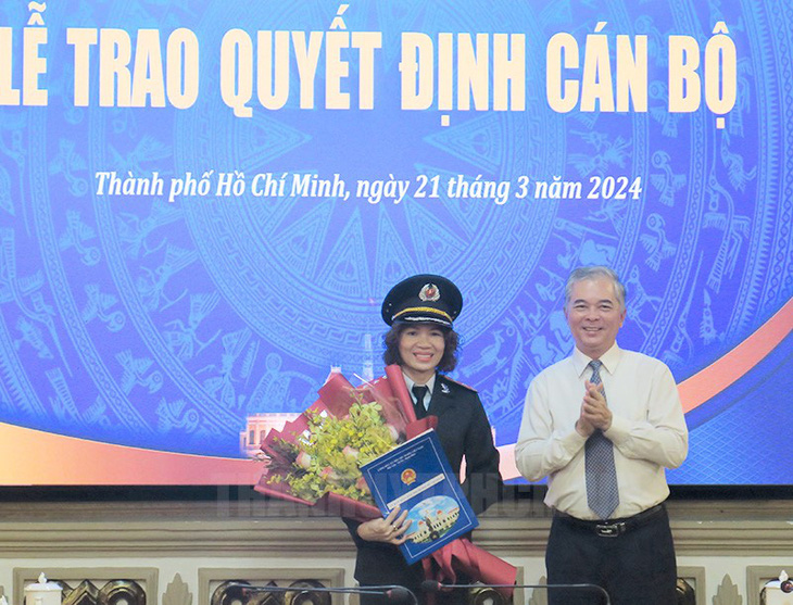 Phó chủ tịch UBND TP.HCM Ngô Minh Châu trao quyết định cho bà Đinh Thị Thu - Ảnh: THÀNH ỦY TP.HCM 