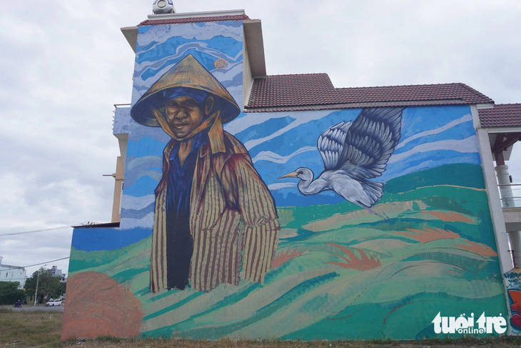 Một bức tranh người nông dân trên cánh đồng được nhóm họa sĩ vẽ trên tường nhà dân - Ảnh: ĐOÀN NHẠN