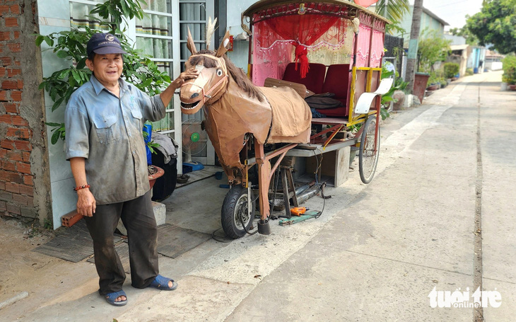 Ông Trần Văn Đúng bên con ngựa tự chế mà ông đang 