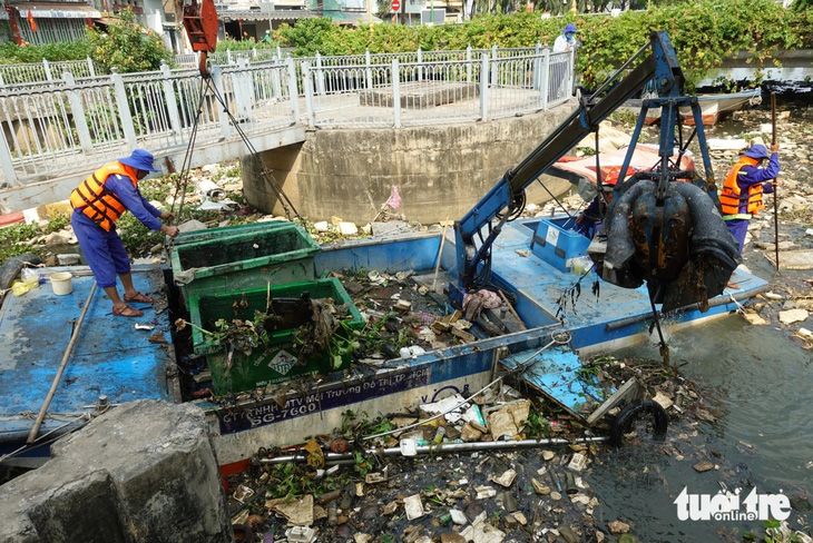 Công nhân vớt rác trên kênh Nhiêu Lộc - Thị Nghè chiều 21-3 - Ảnh: NGUYỄN CÔNG THÀNH