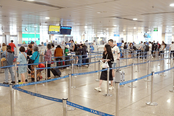 Khách xếp hàng đợi soi hành lý tại sân bay Tân Sơn Nhất vào chiều 20-3 - Ảnh: T.T.D.