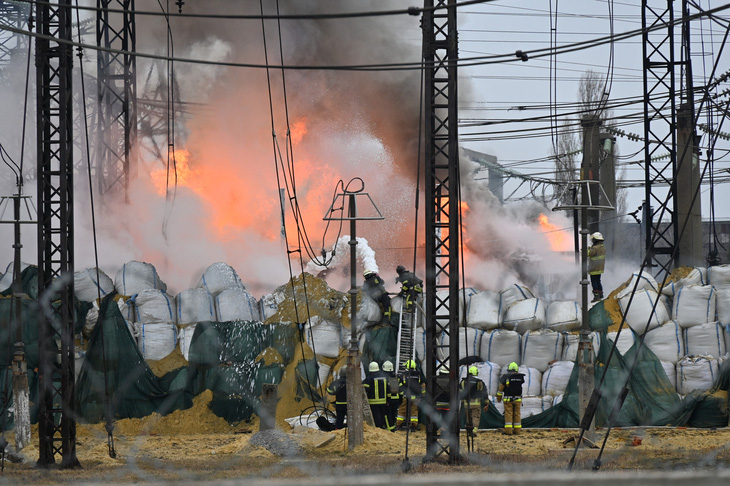 Lính cứu hỏa Ukraine chữa cháy tại một trạm điện bị tên lửa Nga đánh trúng ở vùng Kharkov ngày 22-3 - Ảnh: AFP