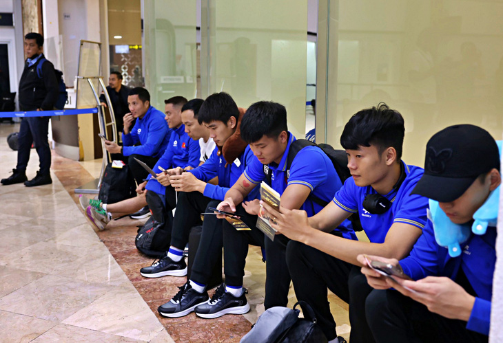 Các cầu thủ Việt Nam ngồi đợi làm thủ tục sau sự cố - Ảnh: VIỆT PHONG
