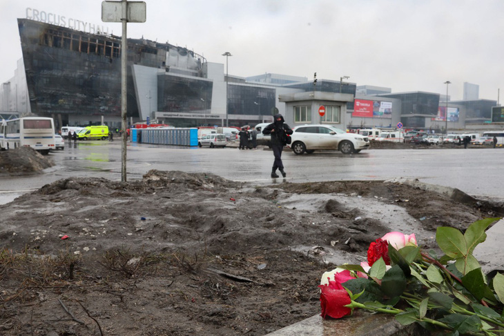 Người dân đặt hoa tại hiện trường vụ xả súng ở Nhà hát Crocus Hall gần thủ đô Matxcơva ngày 23-3 - Ảnh: AFP