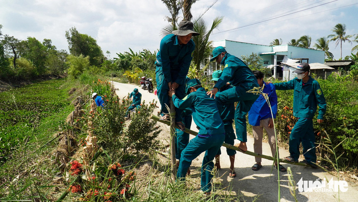 Đội dân quân tự vệ ấp Rạch Cui, xã Khánh Bình, huyện Trần Văn Thời giúp dân gia cố lại con lộ 