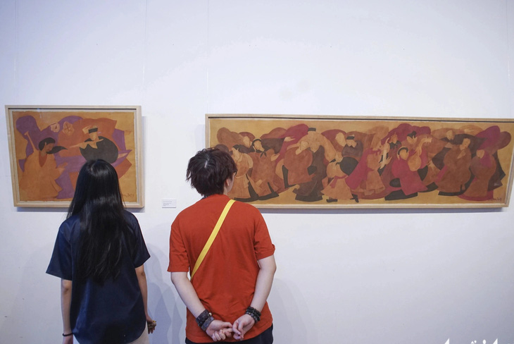 Hai bạn trẻ chăm chú thưởng thức tranh của họa sĩ Phan Cẩm Thượng tại triển lãm - Ảnh: H.VY