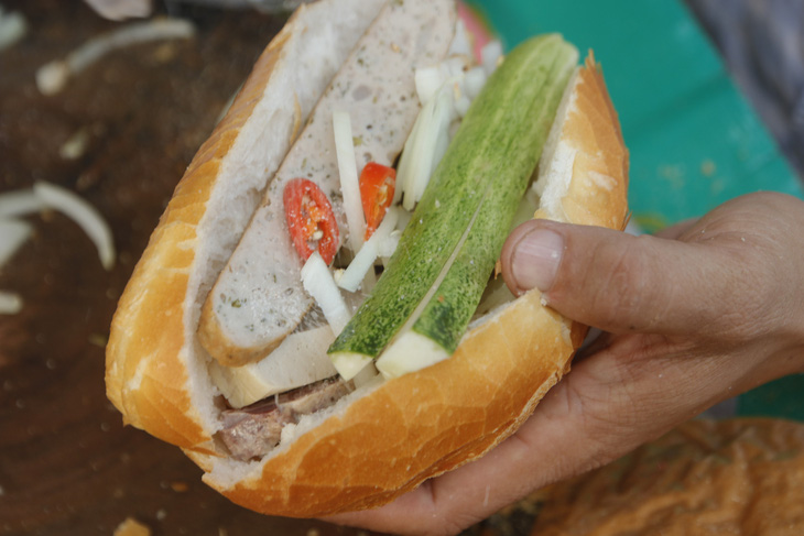 Bánh mì Việt Nam vào top 100 món ăn đường phố hấp dẫn ở châu Á. Trong ảnh là một ổ bánh mì cụ Lý đầy đủ gồm 5 loại chả, dưa leo, ớt, hành tây, nước tương - Ảnh: HỒ LAM