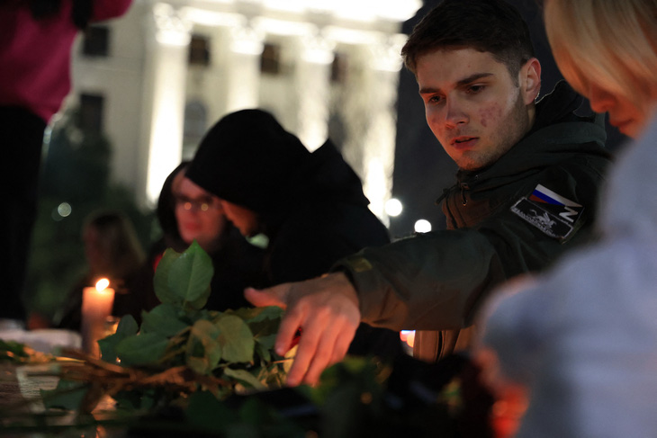 Người dân Crimea đặt hoa, thắp nến tưởng niệm nạn nhân vụ xả súng - Ảnh: AFP