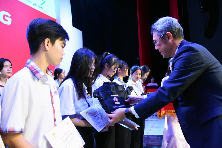 Ông Tetsuya Osawa - giám đốc Công ty Ajinomoto Việt Nam trao học bổng cho các em học sinh - Ảnh: A LỘC