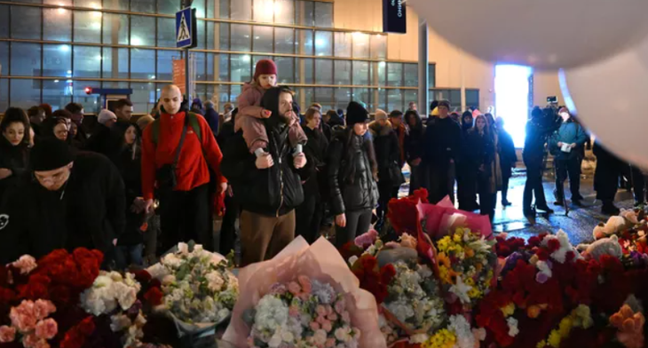 Người dân đặt hoa tưởng niệm các nạn nhân tại thủ đô Matxcơva tối 23-3 - Ảnh: RIA