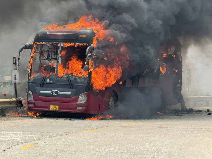Ngọn lửa bao phủ toàn bộ chiếc xe khách và cột khói bốc lên trên đường Hồ Chí Minh - Ảnh: Người dân cung cấp