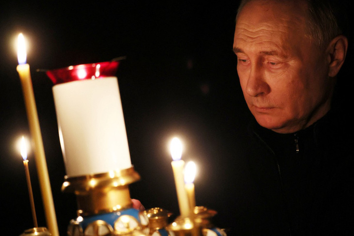 Tổng thống Nga Vladimir Putin thắp nến tại một nhà thờ ở ngoại ô Matxcơva ngày 24-3 - Ảnh: AFP