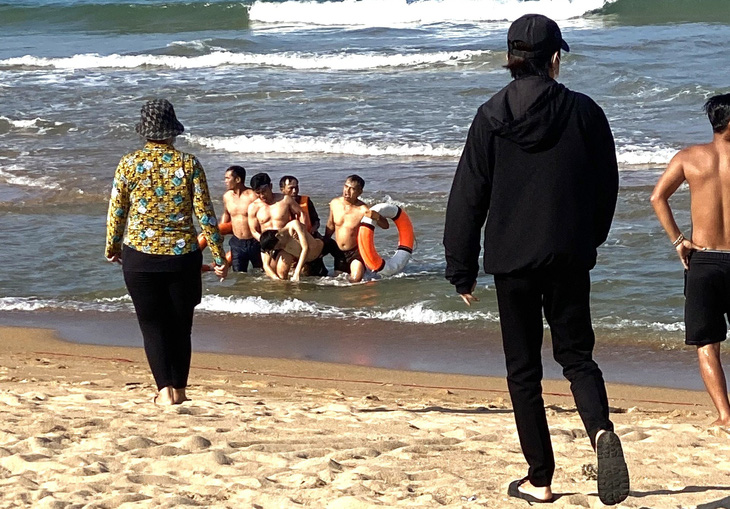 Người dân cùng lực lượng chức năng đưa nạn nhân bị đuối nước lên bờ - Ảnh: KHOA TRẦN