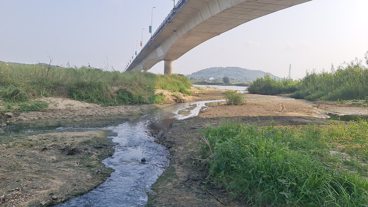 Dòng nước ô nhiễm len lỏi dưới chân cầu Trà Khúc 2 ra sông Trà Khúc - Ảnh: TRẦN MAI