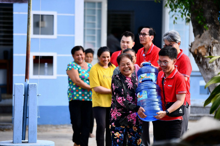 Các tình nguyện viên Keppel hỗ trợ người dân địa phương lấy nước