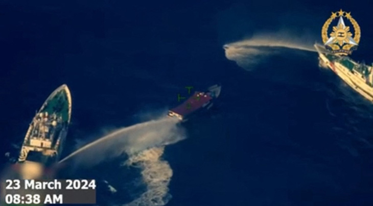 Hình lấy từ video do Philippines quay và công bố ngày 23-3, cho thấy tàu hải cảnh Trung Quốc (trái và phải) phun vòi rồng vào tàu tiếp tế Philippines (giữa) ở bãi Cỏ Mây - Ảnh: AFP