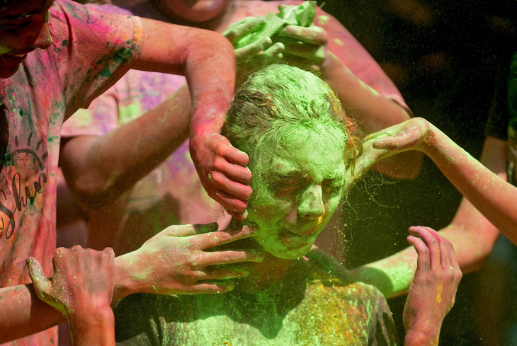 Một cô gái phản ứng khi được bôi bột màu lên mặt trong lễ hội Holi ở Mumbai, Ấn Độ, ngày 25-3 - Ảnh: REUTERS