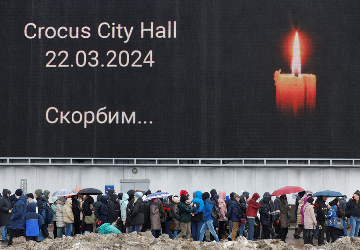 Người dân xếp hàng đặt hoa tại đài tưởng niệm tạm thời, tưởng nhớ các nạn nhân vụ xả súng ở nhà hát Crocus City Hall thuộc khu vực Matxcơva, Nga, ngày 24-3 - Ảnh: REUTERS