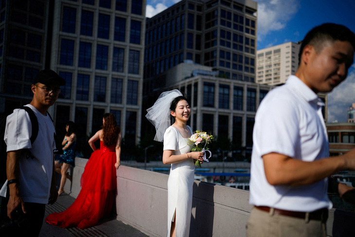 Cô dâu chú rể chụp ảnh cưới trên đường phố Thượng Hải, Trung Quốc - Ảnh: REUTERS