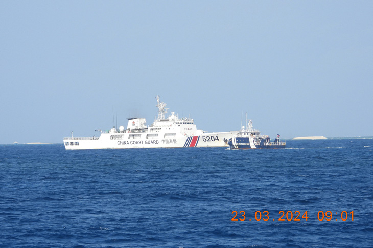 Tàu hải cảnh Trung Quốc (trái) đang chặn tàu Philippines trên đường đến một hòn đảo gần đảo Thị Tứ, thuộc quần đảo Trường Sa của Việt Nam, ngày 23-3 - Ảnh: AFP