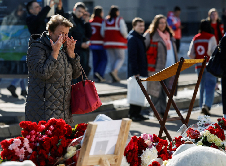 Một người dân xúc động tại điểm tưởng niệm các nạn nhân gần Nhà hát Crocus City Hall, vùng Matxcơva (Nga) ngày 27-3 - Ảnh: REUTERS