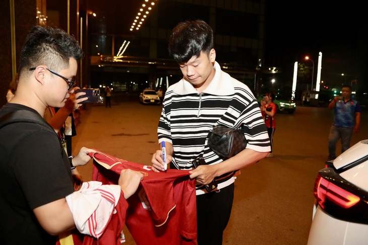 Trung vệ Nguyễn Thành Chung (biên chế CLB Hà Nội) ký tặng người hâm mộ trước khi trở về nhà - Ảnh: NGUYÊN KHÔI